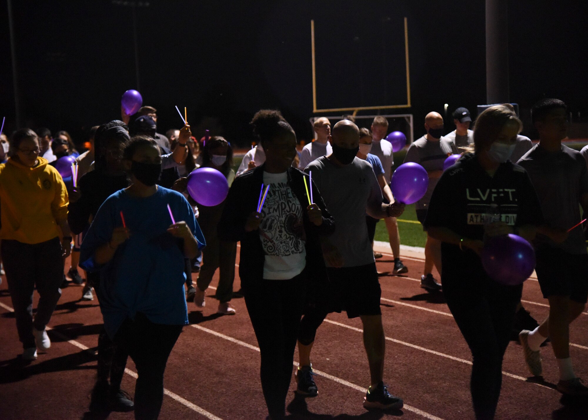 Goodfellow members walk with glow stick in the air during the Suicide Awareness 24-Hour Run/Walk on Goodfellow Air Force Base