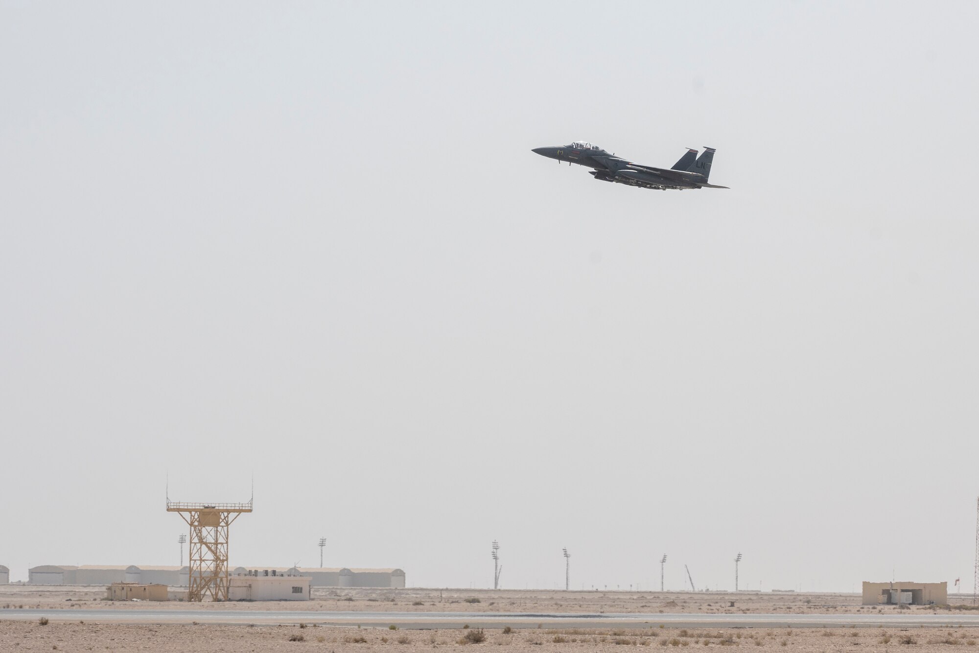 F-15 jet in flight over runway