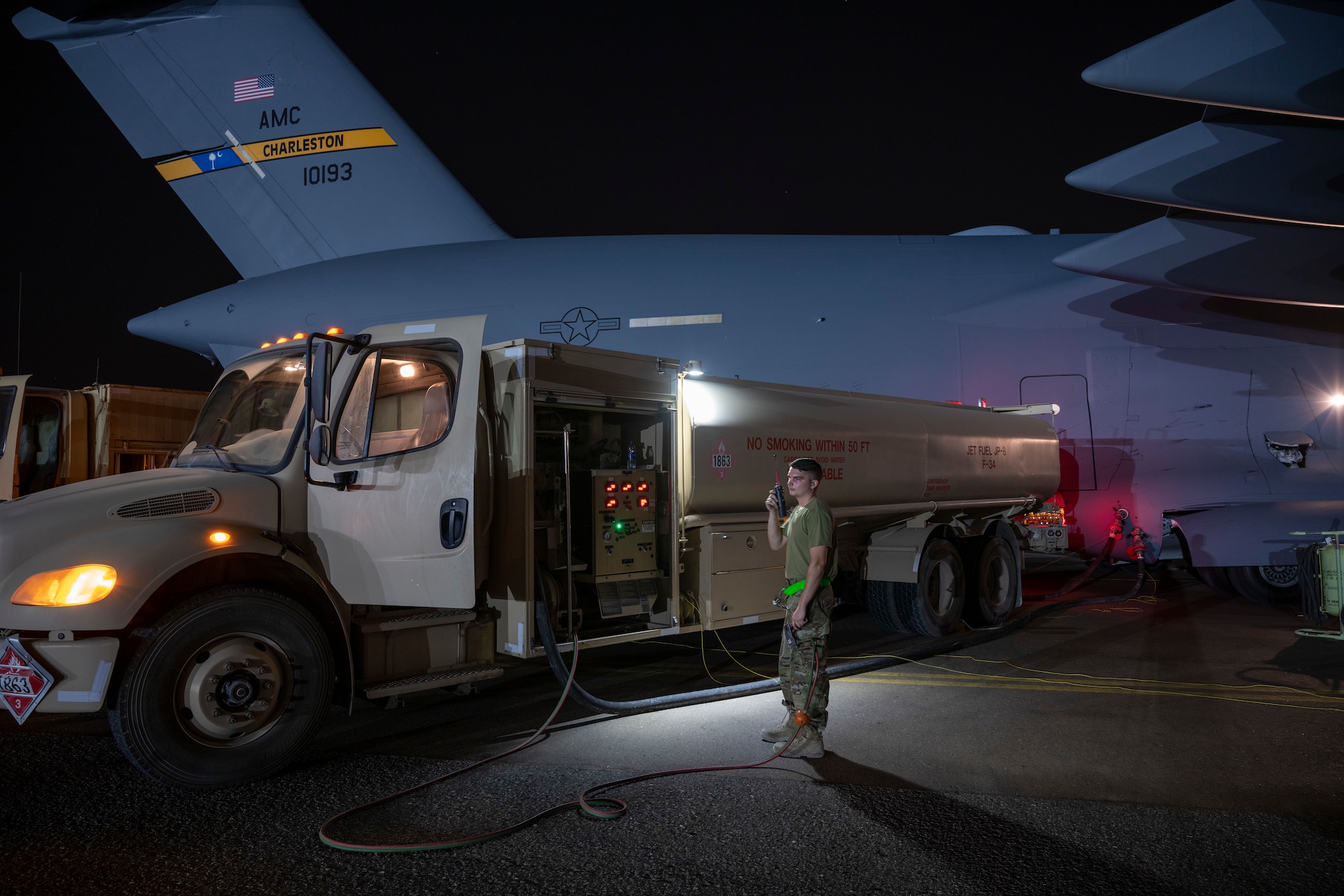 Airman with fuel truck refueling C-17 aircraft
