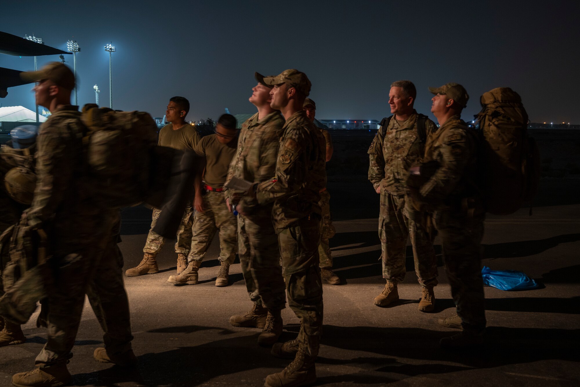 Airmen watching as members board an aircraft