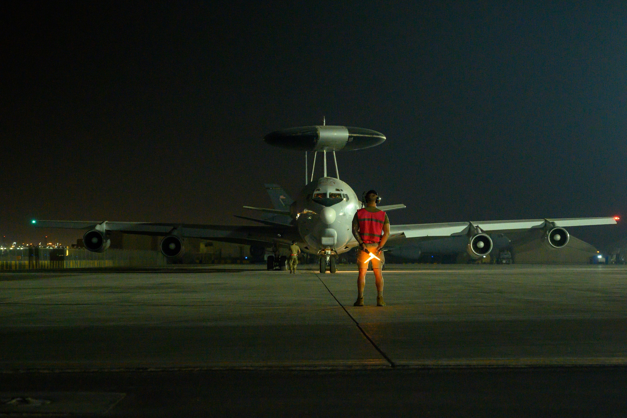 Crew chief stands in front of an E-3 in preparation to taxi