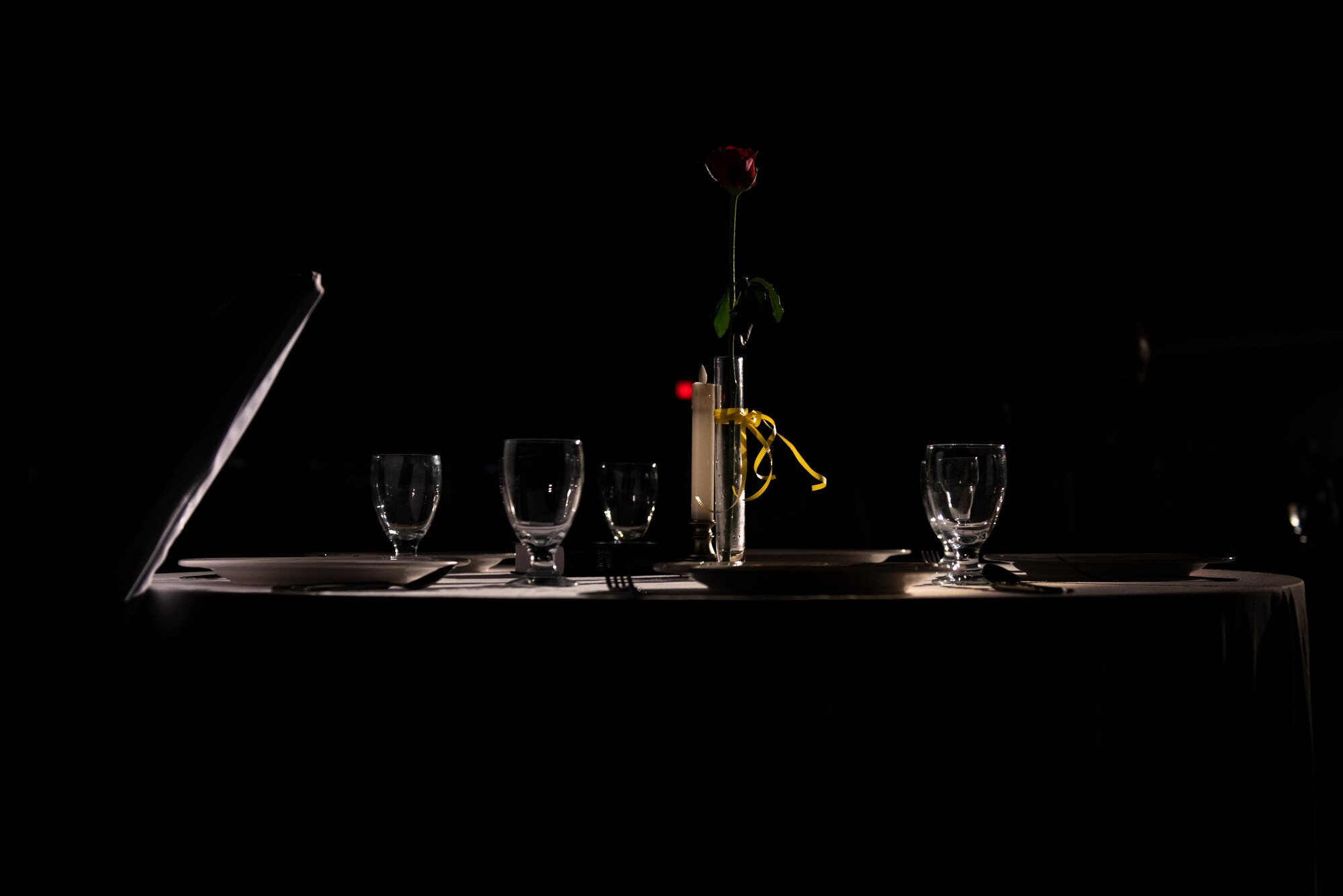 A spotlight shines on the Prisoner of War and Missing in Action memorial table during a remembrance ceremony held during the Senior Noncommissioned Officer Induction Ceremony