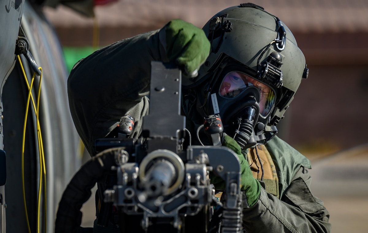 An Airman assigned to the 88th Test and Evaluation Squadron performs pre-flight checks on an HH-60G Pave Hawk helicopter in full Chemical, Biological, Radiological, and Nuclear flight gear during a developmental test at Nellis Air Force Base, April 21, 2021. Airmen provided individual notes to assessors following the test in order to make changes or improvements. (U.S. Air Force photo by Senior Airman Dwane R. Young)
