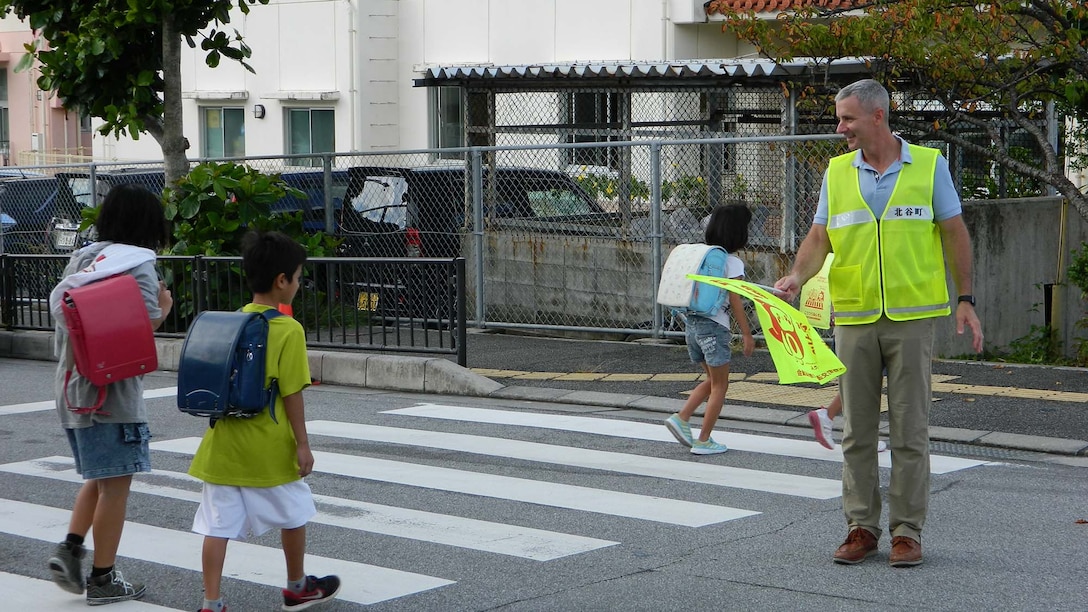 北谷町立北玉小学校前で朝の登校時、子どもたちの安全を笑顔で見守る前基地司令官チコーリー大佐