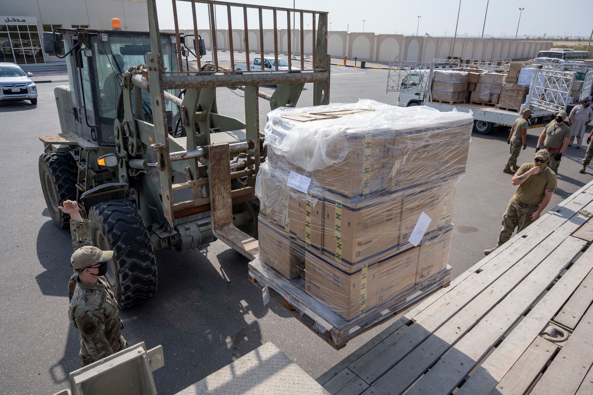 Airmen loading and packing pallets of humanitarian supplies