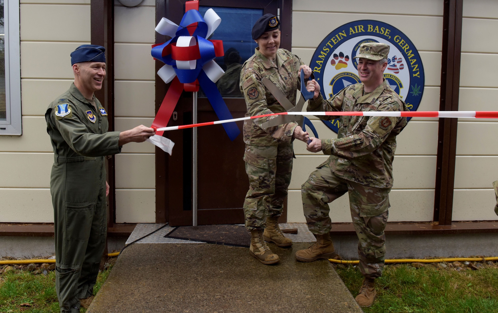 U.S. Air Force Col. Calvin B. Powell, Lt. Col. Cassandra Bates and Lt. Col. Seth Pratt cut the ribbon at a ribbon-cutting ceremony