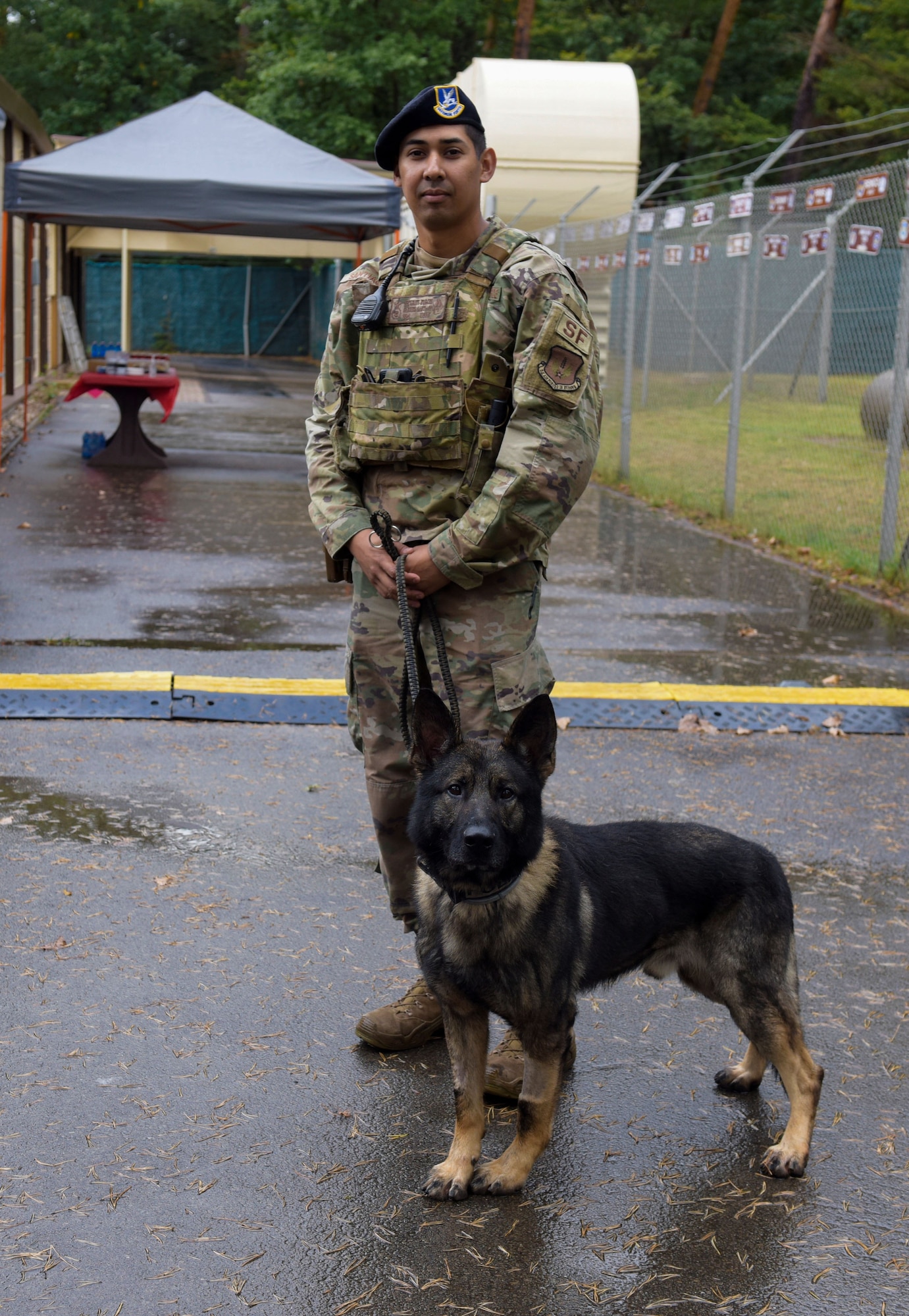 U.S. Air Force Staff Sgt. Gabriel Santiago stands outside with his MWD, Arthur