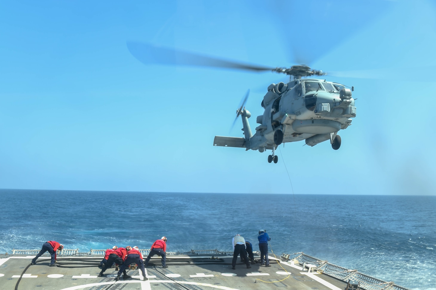 210827-N-UP745-1174 ATLANTIC OCEAN (Aug. 27, 2021) Sailors hold a fuel pump during a helicopter-inflight-refueling of an MH-60R Sea Hawk aboard USS Forrest Sherman (DDG 98). USS Forrest Sherman (DDG 98) participates in FRONTIER SENTINEL alongside U.S. Coast Guard, and Canadian Allies to enhance their Arctic capabilities. (U.S. Navy Photo by Mass Communication Specialist Seaman Theoplis Stewart II/Released)