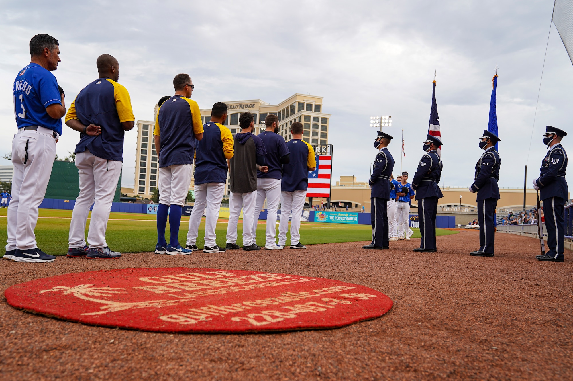 Biloxi Shuckers team members place their right hand over their hearts as the Keesler Honor Guard prepares to present colors during the Biloxi Shuckers Minor League Baseball game in Biloxi, Mississippi, September 18, 2021.The Shuckers hosted a military appreciation night where service members received free tickets. (U.S. Air Force photo by Senior Airman Spencer Tobler)