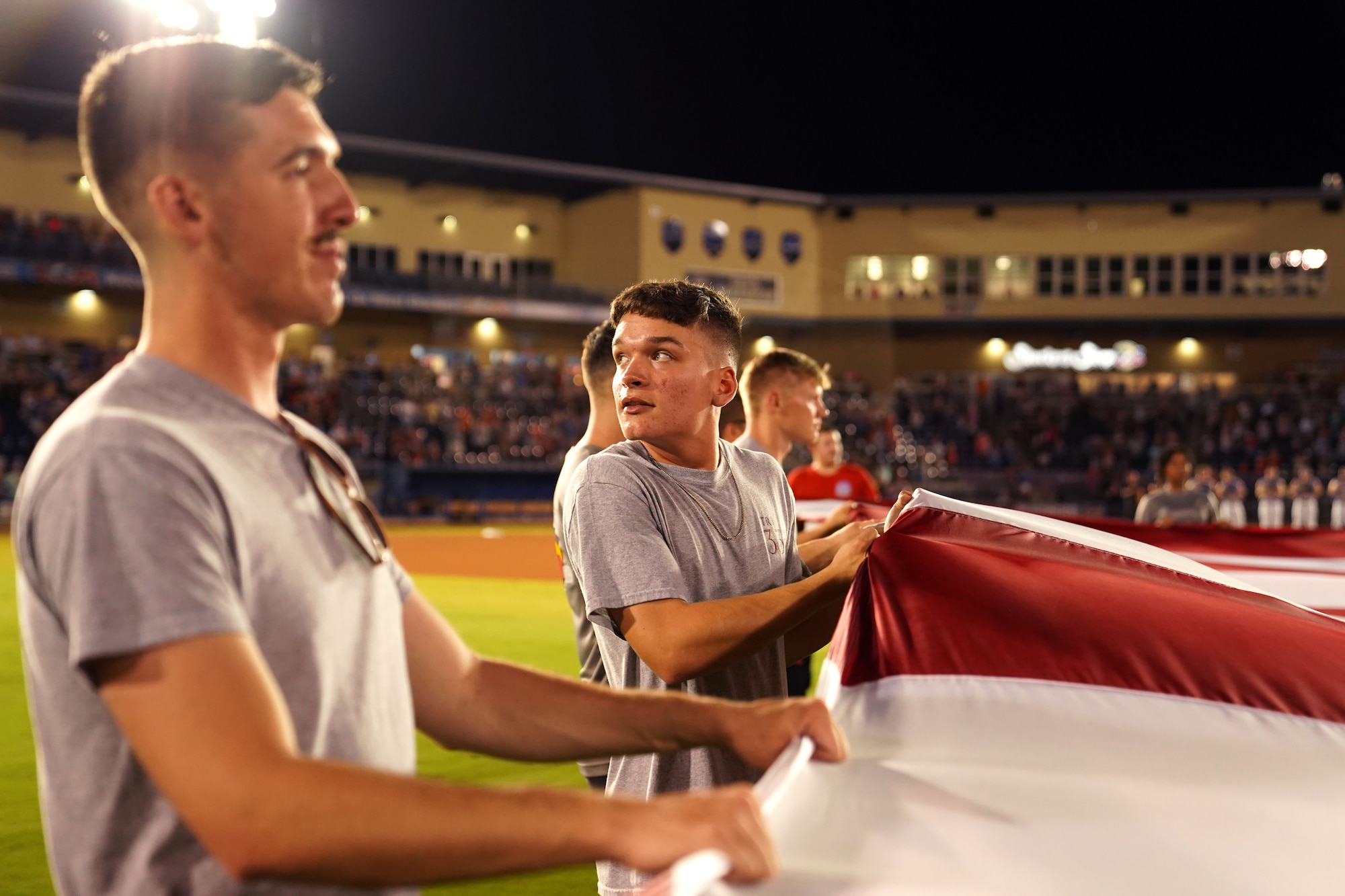 Keesler Airmen hold a U.S. flag during the Biloxi Shuckers Minor League Baseball game in Biloxi, Mississippi, September 18, 2021. The Shuckers hosted a military appreciation night where service members received free tickets. (U.S. Air Force photo by Senior Airman Spencer Tobler)