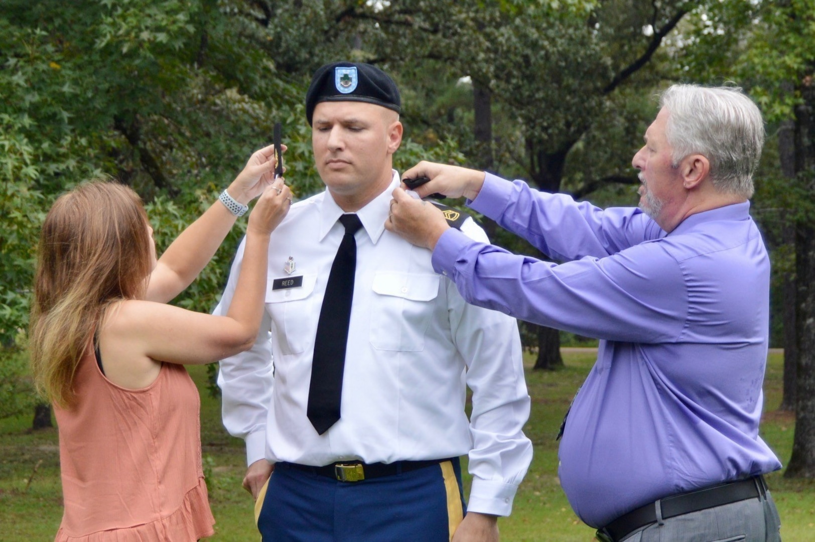 Sgt. 1st Class Johnathan Reed was promoted by his father (right), retired Sgt. 1st Class Jack Reed and his wife (left) Christy Reed.