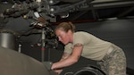 Black Hawk mechanic replaces a part on a helicopter.