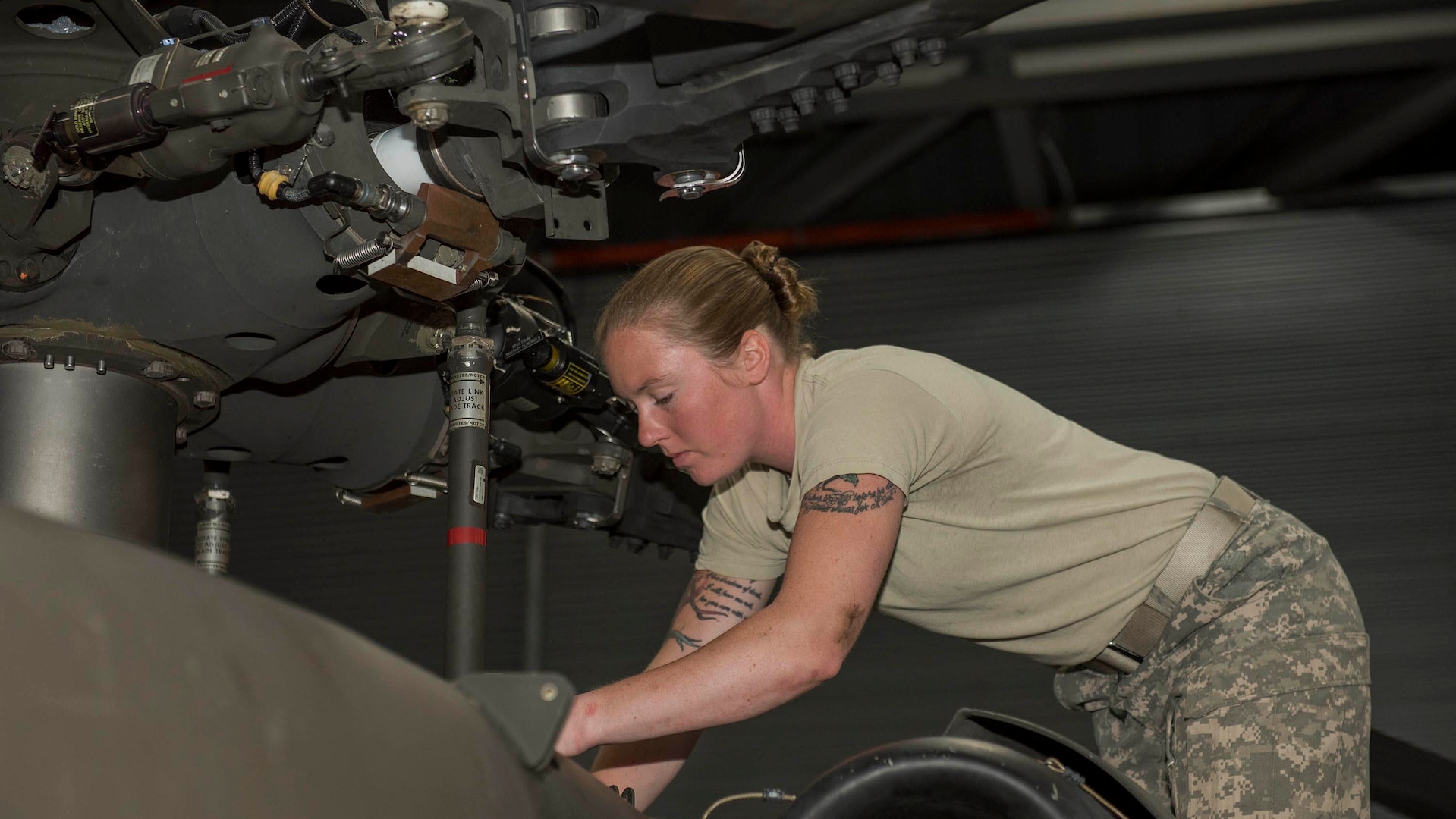 Black Hawk mechanic replaces a part on a helicopter.