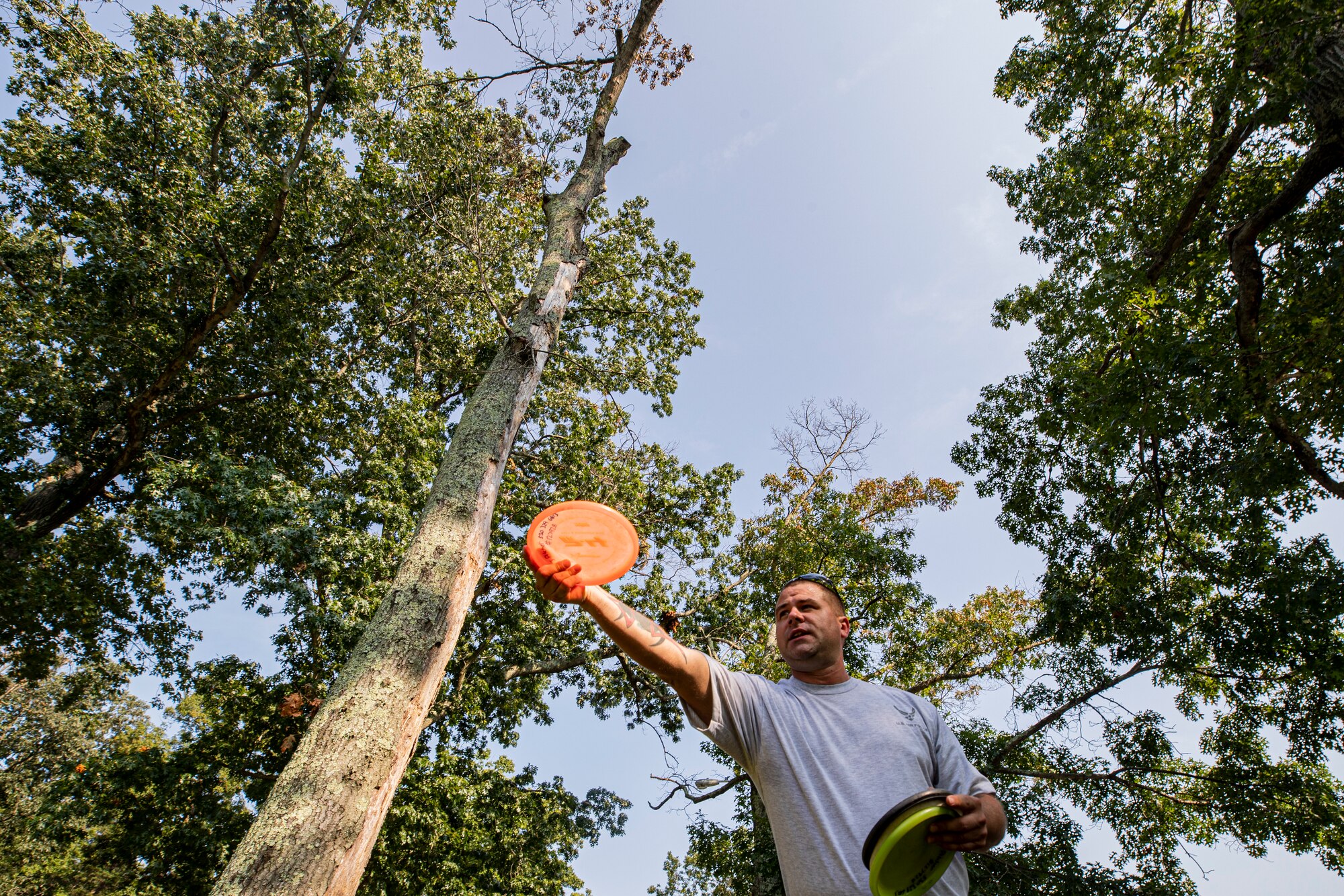 U.S. Air Force Senior Master Sgt. Jefferey Pitcher, a logistics specialist with Joint Force Headquarters-Air, demonstrates how to throw a disc at the Laurel Pond Disc Golf Course during a training session on Joint Base McGuire-Dix-Lakehurst, N.J., Sept. 12, 2021.