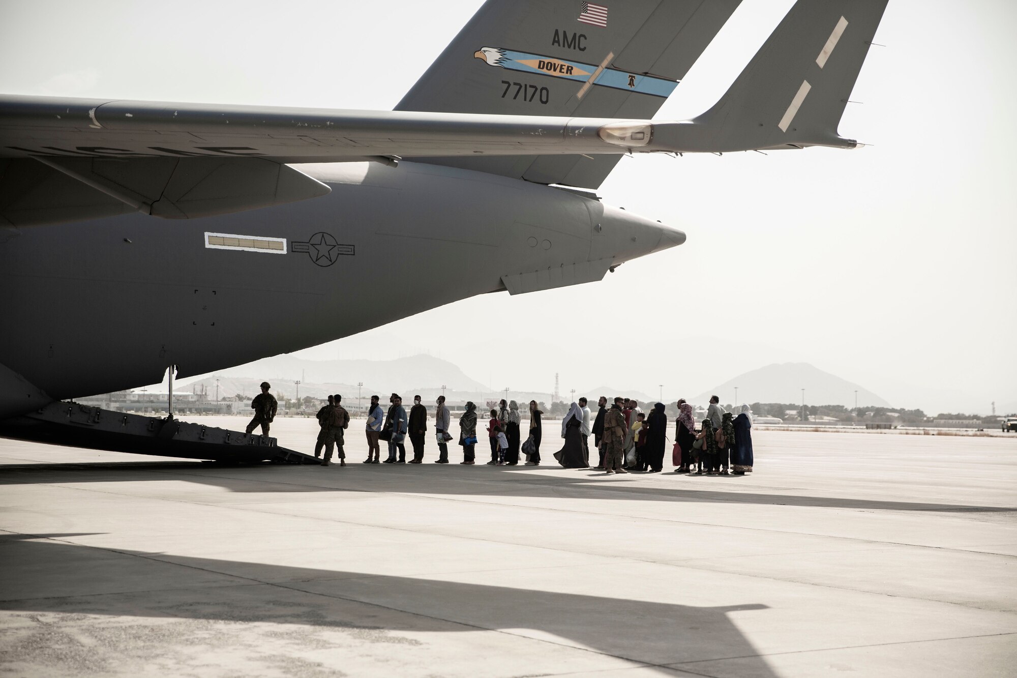 Evacuees wait to board a Boeing C-17 Globemaster III during an evacuation at Hamid Karzai International Airport, Kabul, Afghanistan, Aug. 30. U.S. service members are assisting the Department of State with a Non-combatant Evacuation Operation (NEO) in Afghanistan. (U.S. Marine Corps photo by Staff Sgt. Victor Mancillal)