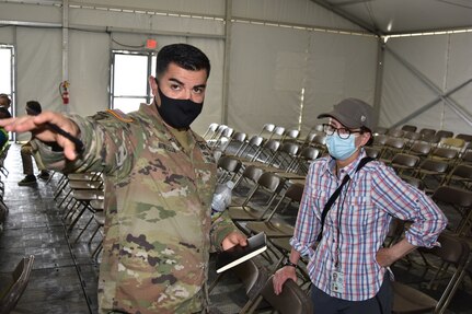 Maj. Victor Montellano talks to Michelle Weinberg about COVID-19 procedures in July at Fort Lee, Virginia.