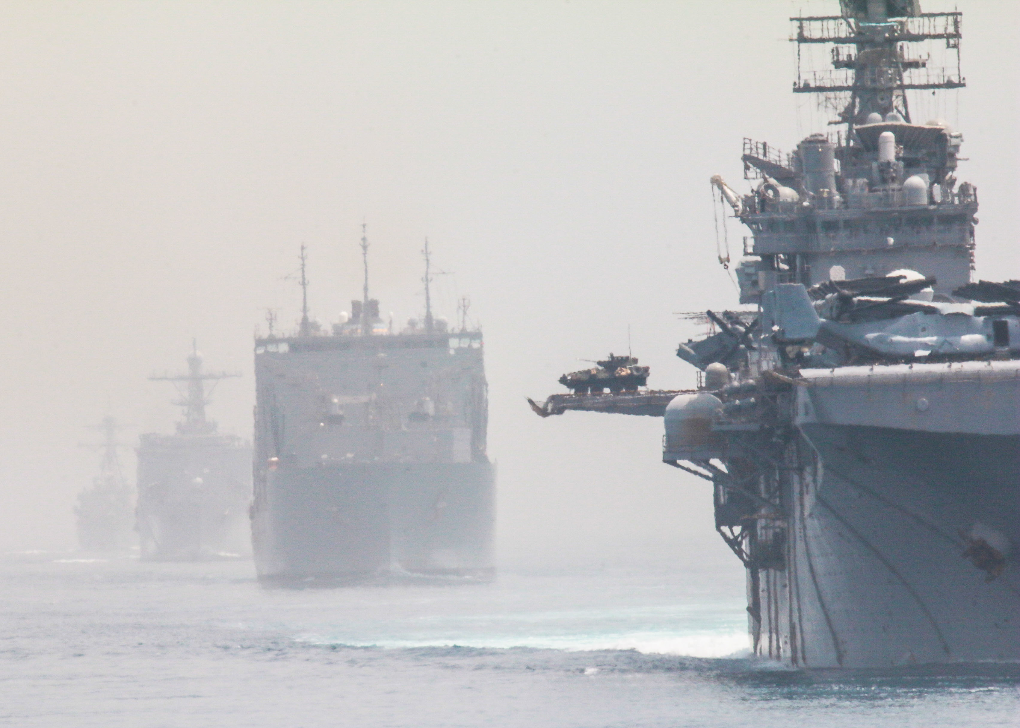 Amphibious assault ship USS Iwo Jima (LHD 7), right, Military Sealift Command dry cargo and ammunition ship USNS William Mclean (T-AKE 12), center, dock landing ship USS Carter Hall (LSD 50), guided missile destroyer USS Mitscher (DDG-57) and the amphibious transport dock ship USS San Antonio (LPD 17), not pictured, transit the Red Sea, July 4, 2021.