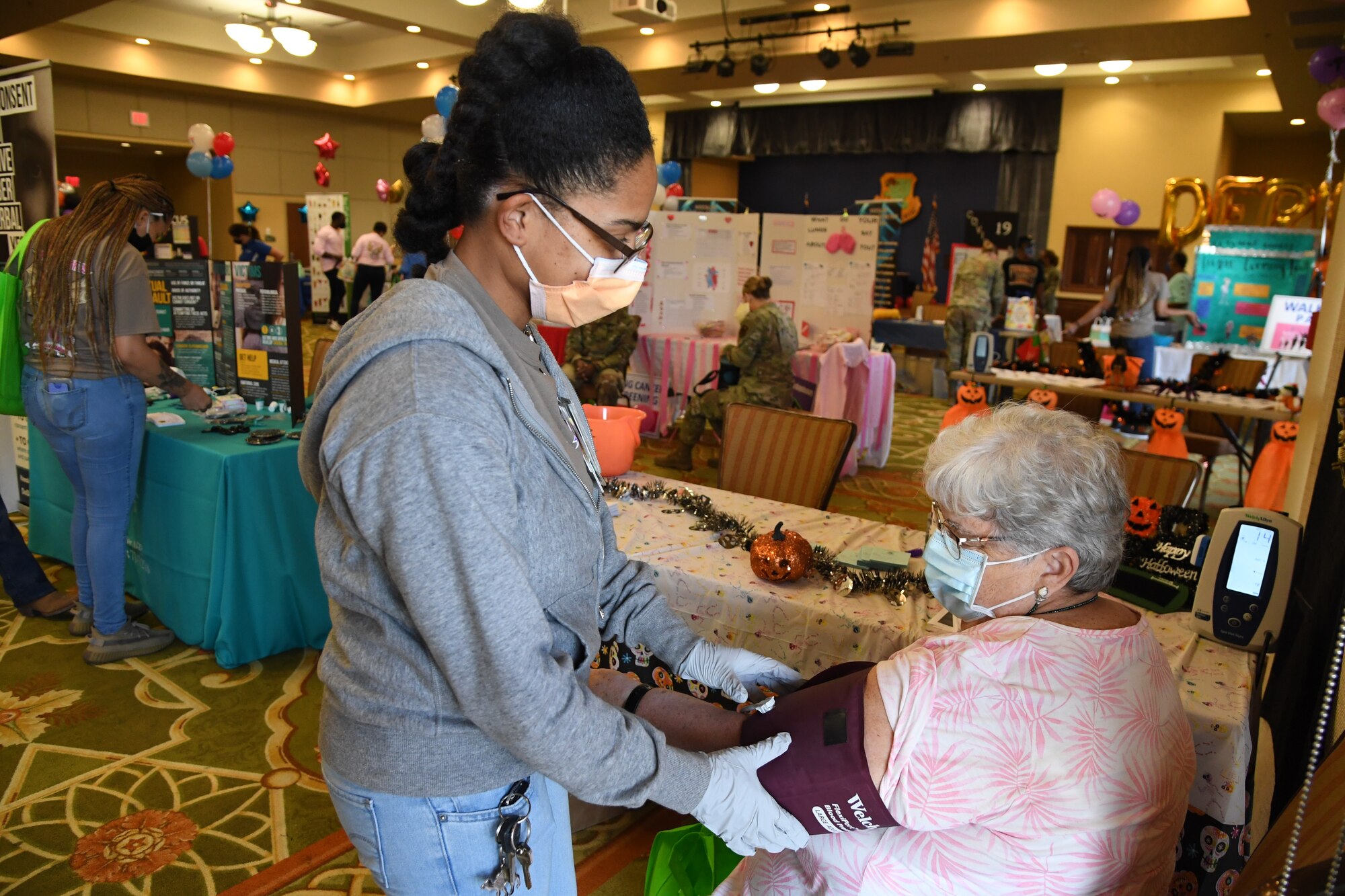 U.S. Air Force Capt. Zina Plummer, 81st Healthcare Operations Squadron registered nurse, checks the blood pressure on Paula Carrigan, wife of Retired Chief Master Sgt. Charlie Carrigan, during the 10th Annual 81st Medical Group Health Expo inside the Bay Breeze Event Center at Keesler Air Force Base, Mississippi, October 1, 2021. The 81st MDG hosted the walk-in event which included information booths and scheduling appointments for multiple types of cancer and chronic diseases in honor of Breast Cancer Awareness Month. (U.S. Air Force photo by Kemberly Groue)