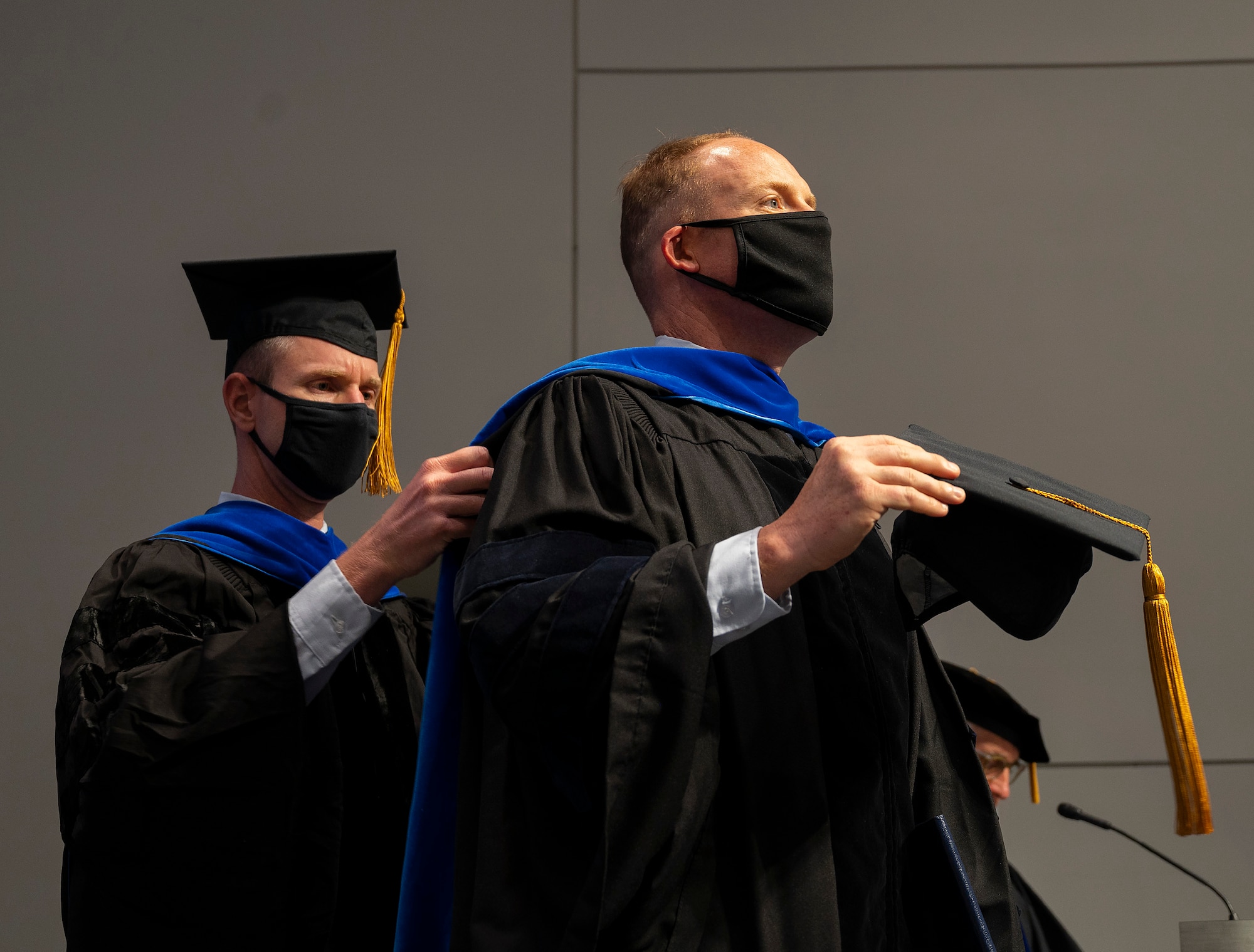 During an Air Force Institute of Technology graduation ceremony on Sept. 16, 2021, Lt. Col. James Rutledge, associate professor of aerospace engineering and senior military faculty, adjusts the hood of his student, Lt. Col. Matthew Fuqua, as Fuqua receives his Doctor of Philosophy in Aeronautical Engineering. (U.S. Air Force photo by R.J. Oriez)