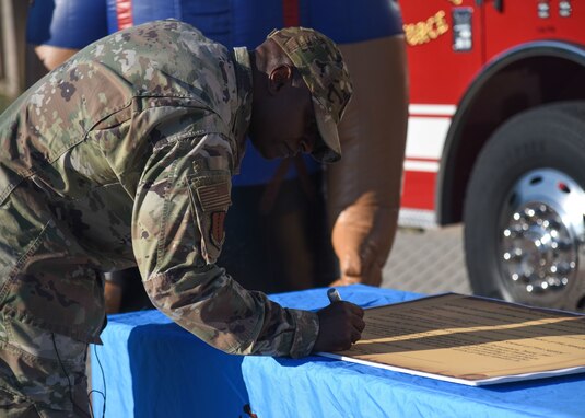 U.S. Air Force Col. James Finlayson, 17th Training Wing vice commander, signs a proclamation declaring the second week of Oct. as Fire Prevention Week on Goodfellow Air Force Base.