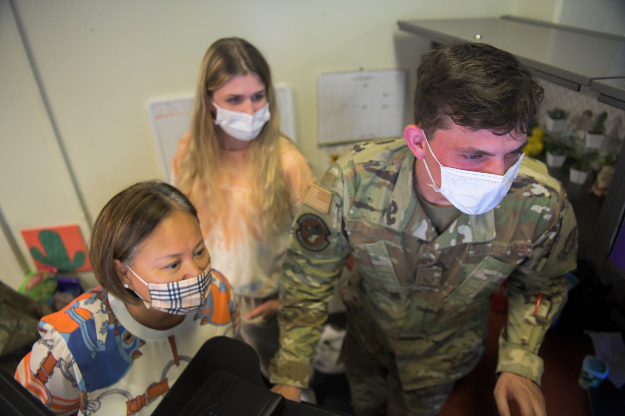Contracting personnel look at computer.