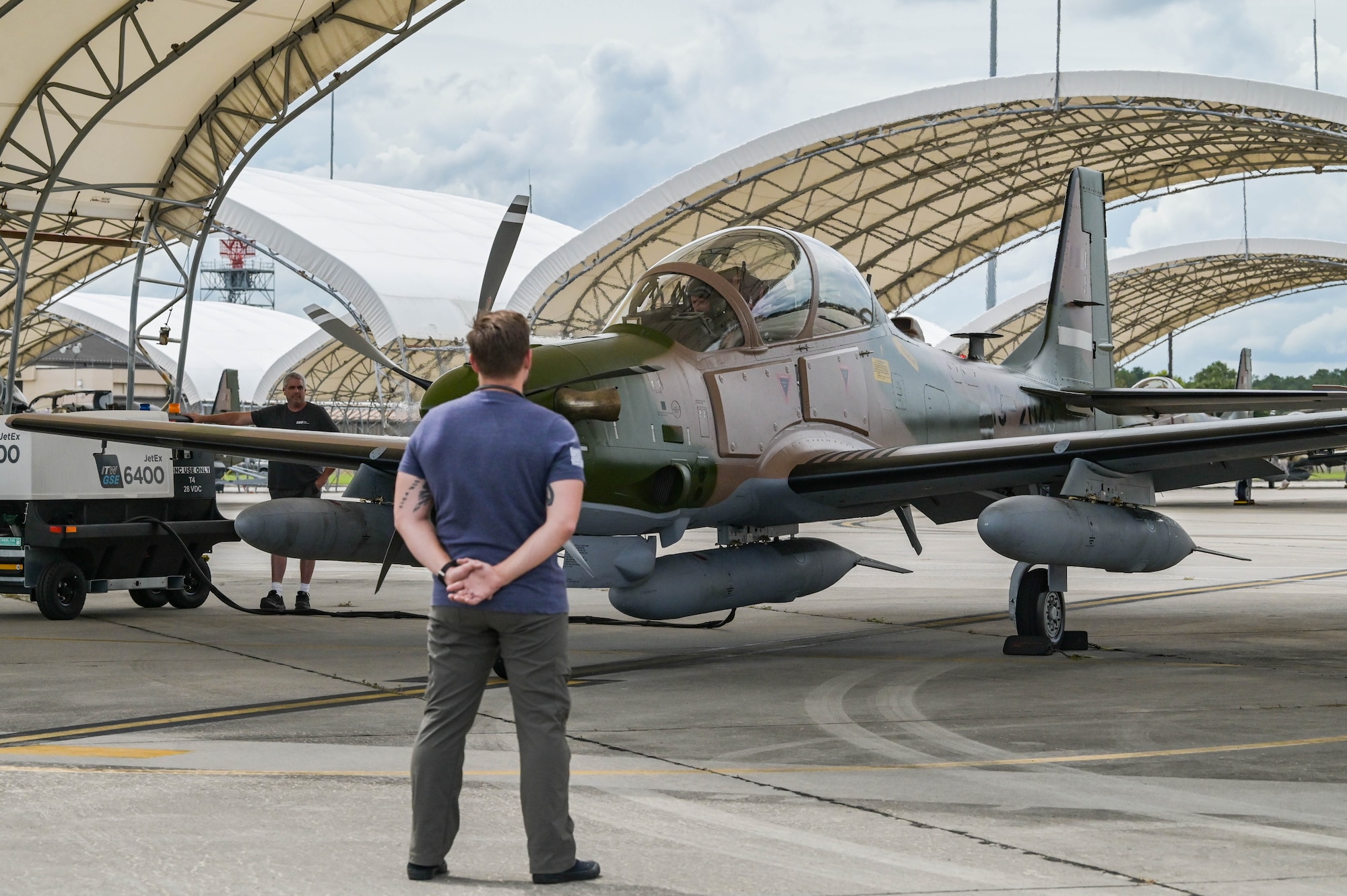 U.S. Air Force contractor Travis Smith, 81st Fighter Squadron A-29 Super Tucano aircraft technician, prepares to marshal an A-29 Super Tucano pilot for departure at Moody Air Force Base, Georgia, Sept. 15, 2021. The aircraft are being transported to Nigeria by U.S. Air Force contracted pilots. (U.S. Air Force photo by Senior Airman Rebeckah Medeiros)