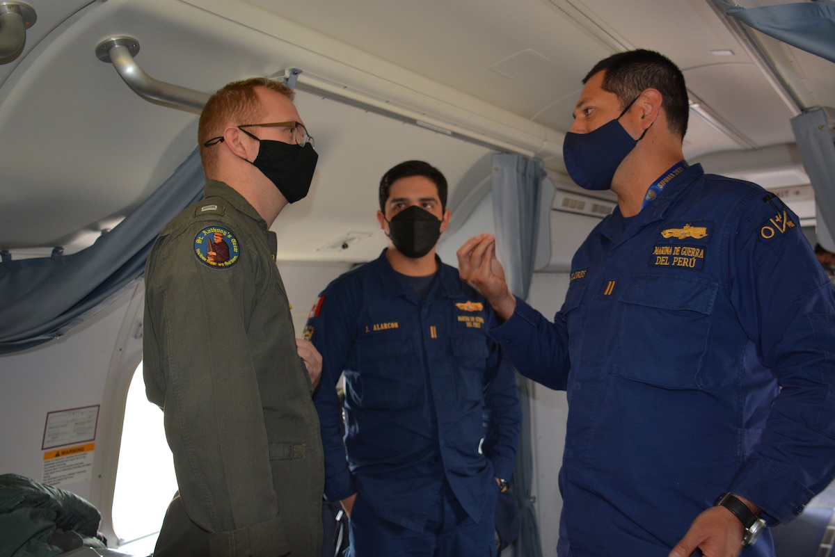 U.S. Navy Lt. Ryan Johnson discusses best practices with Peruvian navy Lt. Jorge Renato Alarcon Ulloa and Lt. Marco Antonio Flores Palomino aboard a P-8A Poseidon aircraft attached to the "Golden Eagles" of Patrol Squadron (VP) 9 during an intelligence, surveillance and reconnaissance (ISR) mission flight as part of UNITAS LXII.