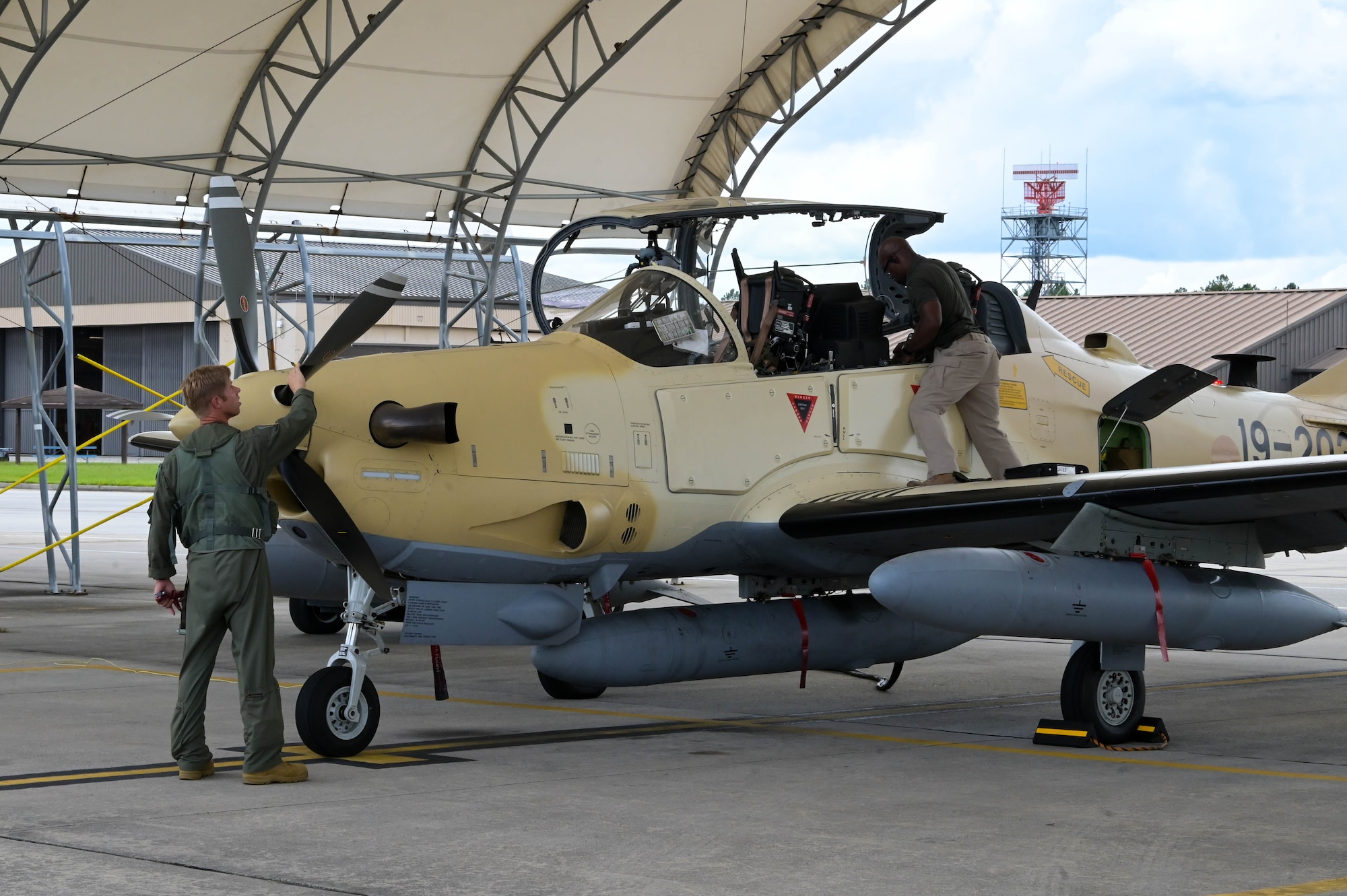 An A-29 Super Tucano aircraft pilot from the 81st Fighter Squadron, left, performs a preflight inspection at Moody Air Force Base, Georgia, Sept. 15, 2021. After more than a year of training, the final batch of aircraft are finally being sent to Nigeria. (U.S. Air Force photo by Senior Airman Rebeckah Medeiros)