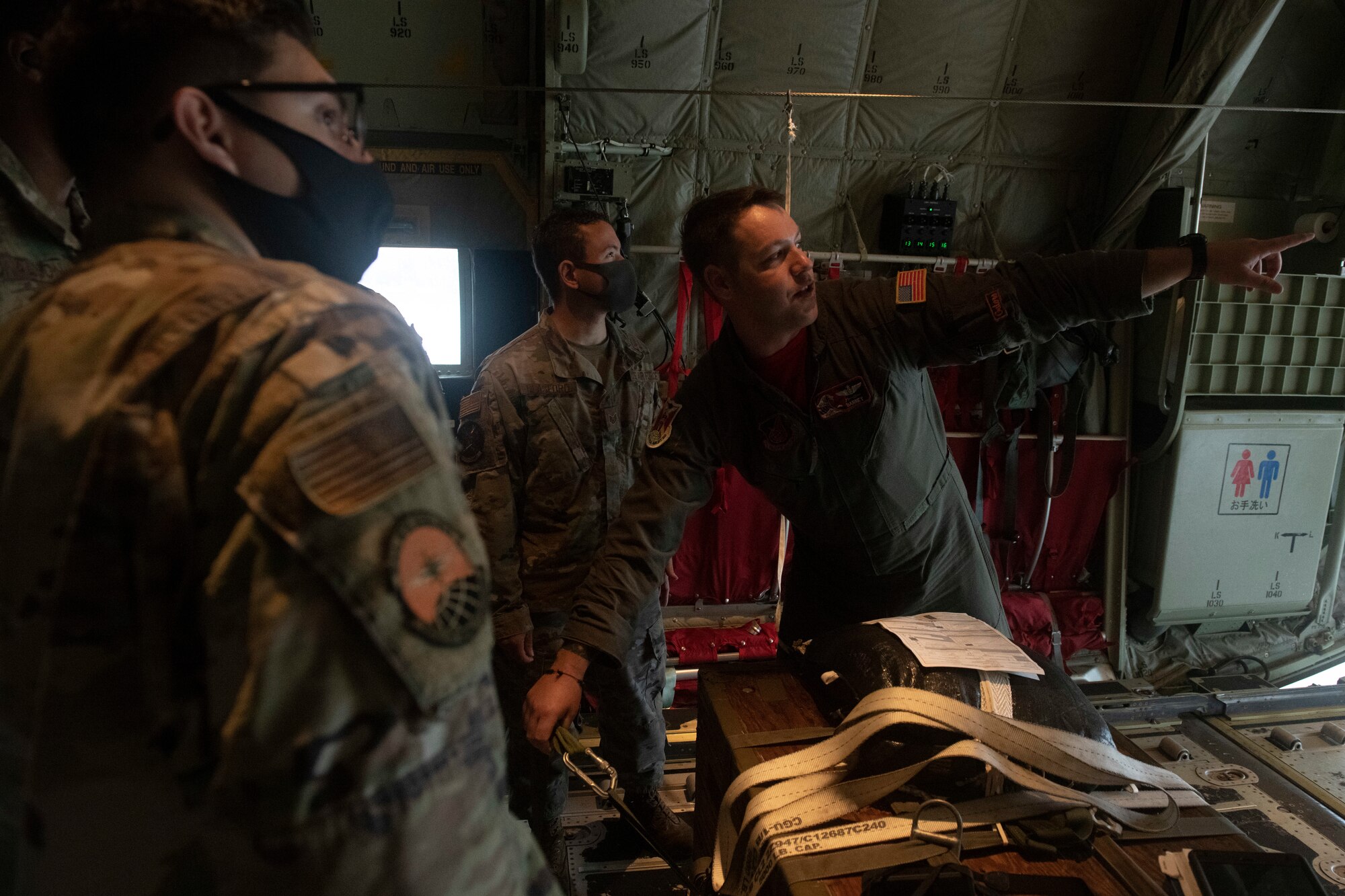 Tech. Sgt. Chad Barnette, 36th Airlift Squadron evaluator loadmaster, right, informs Airmen about parachute rigging on a cargo pallet prior to an incentive flight at Yokota Air Base, Japan, Oct. 1, 2021. Barnette explained how loadmasters rig various types of cargo and the differences in the types of airdrops they perform. (U.S. Air Force photo by Staff Sgt. Joshua Edwards)