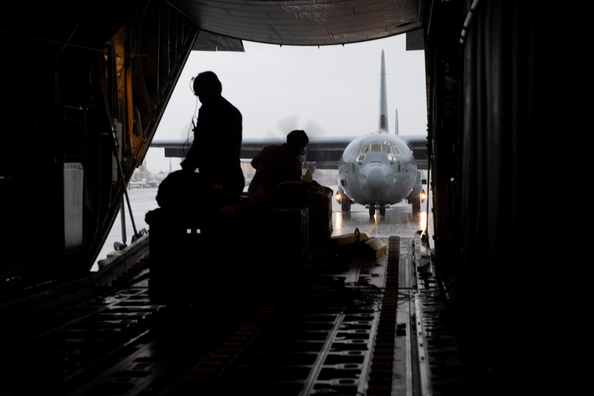 Tech. Sgt. Chad Barnette, 36th Airlift Squadron C-130J Super Hercules evaluator loadmaster, left, and Senior Airman Jerlmie Brumfield, 36th Airlift Squadron loadmaster, wait while a C-130J taxis after an incentive flight at Yokota Air Base, Japan, Oct. 1, 2021. The 36th AS used six C-130Js to showcase the flying mission during the incentive flight. (U.S. Air Force photo by Staff Sgt. Joshua Edwards)