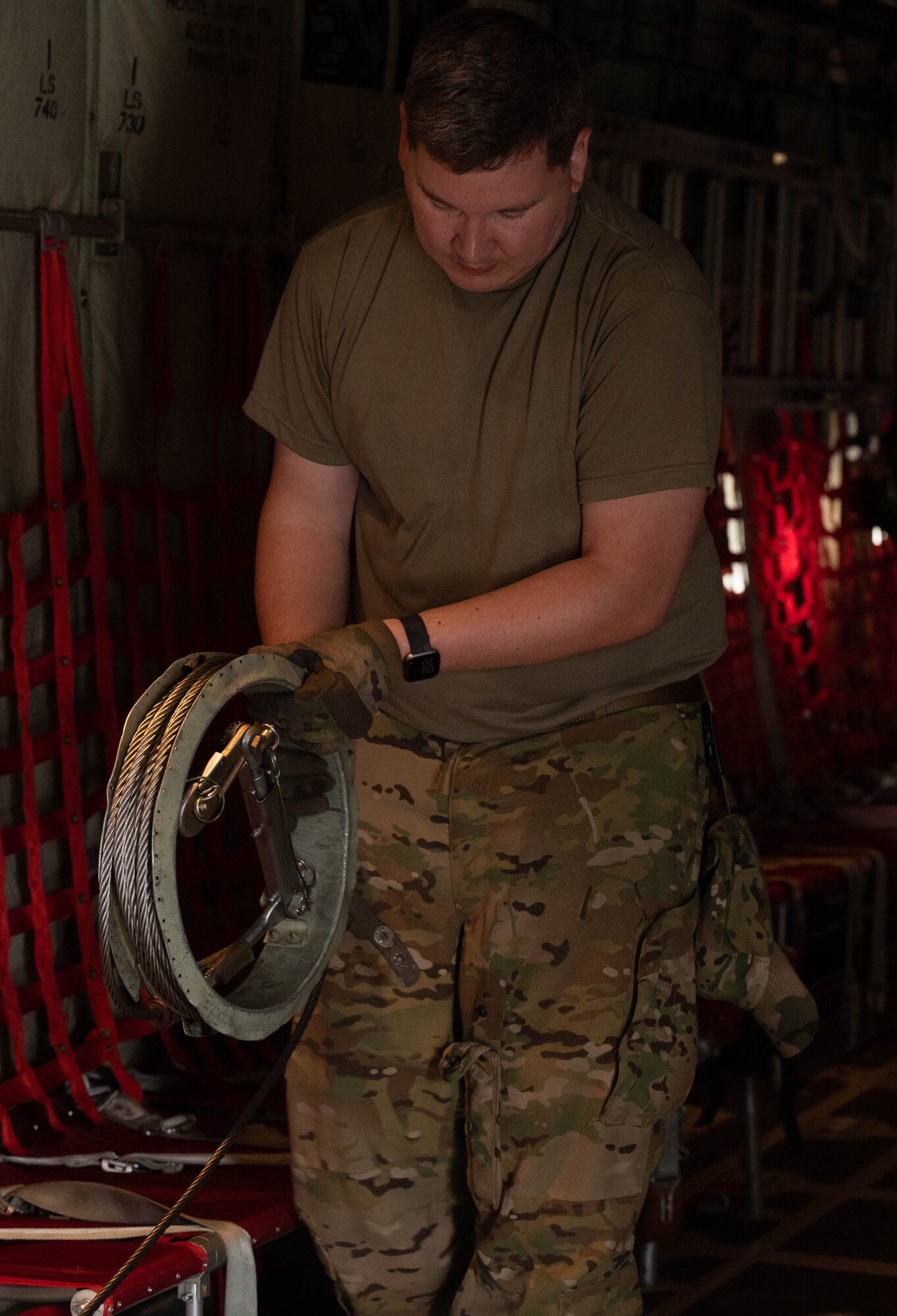 An Airman reels in an anchor cable.