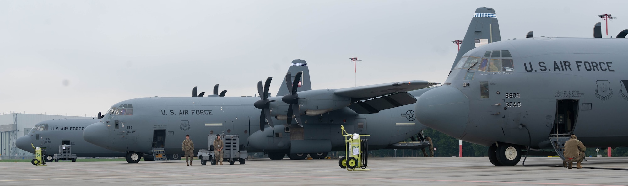 Three C-130J Super Hercules aircraft lay on the flight line.
