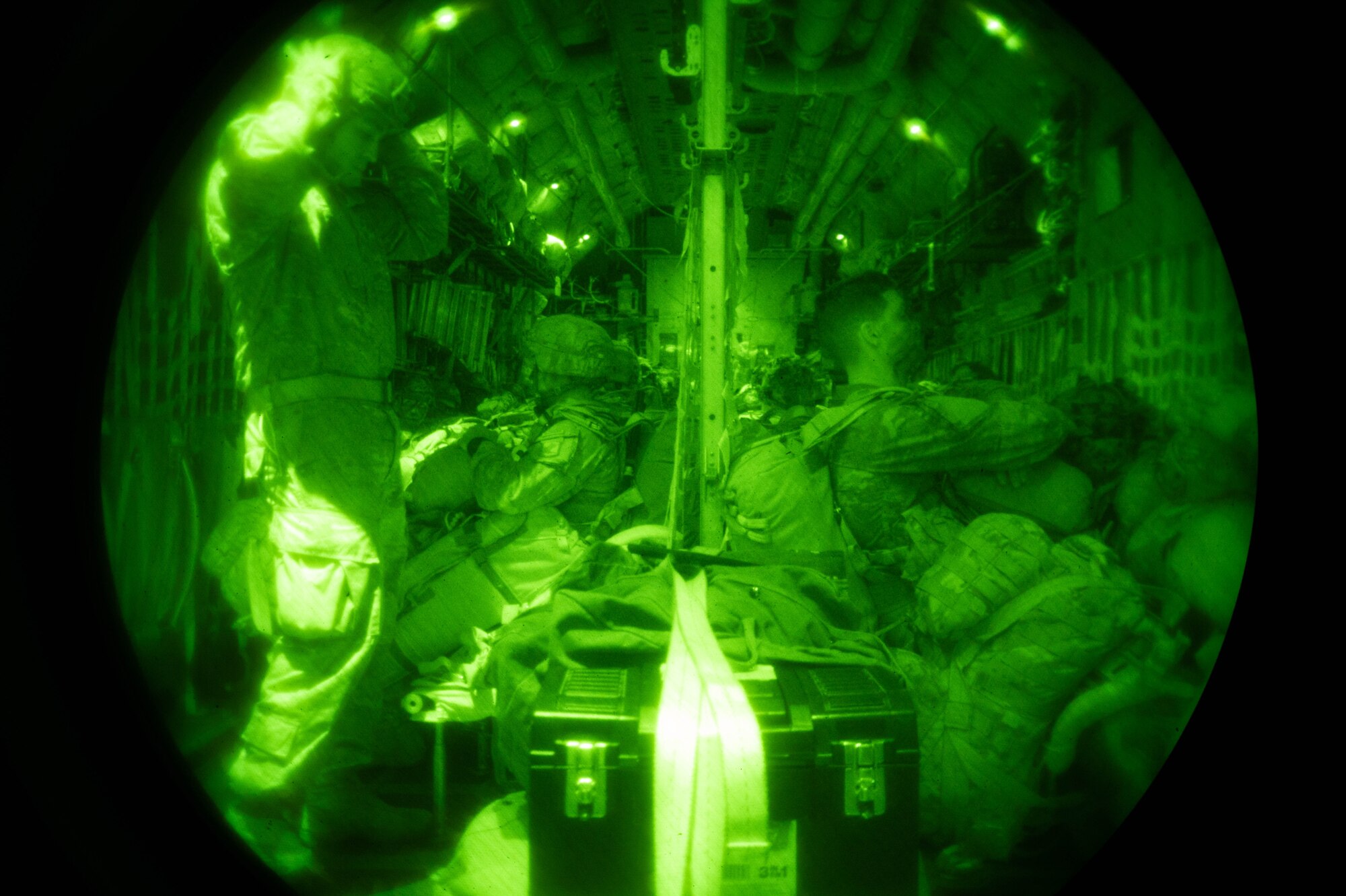 Soldiers sit inside of a C-130J Super Hercules aircraft.