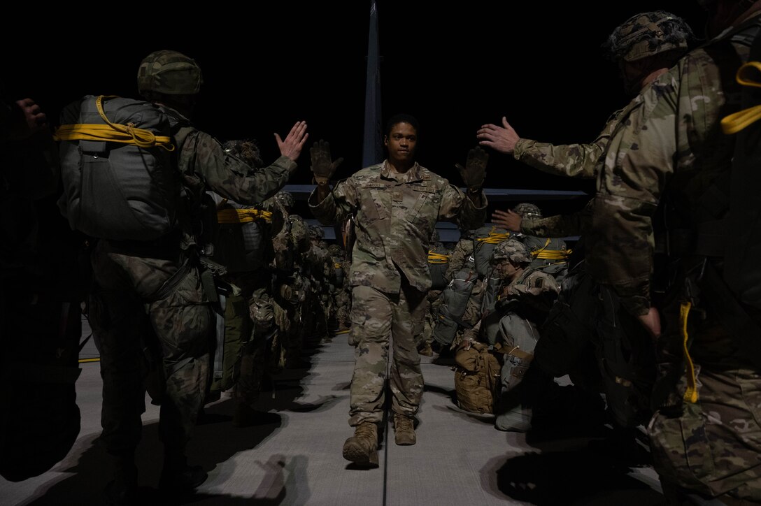 An Airmen gives high-fives to soldiers