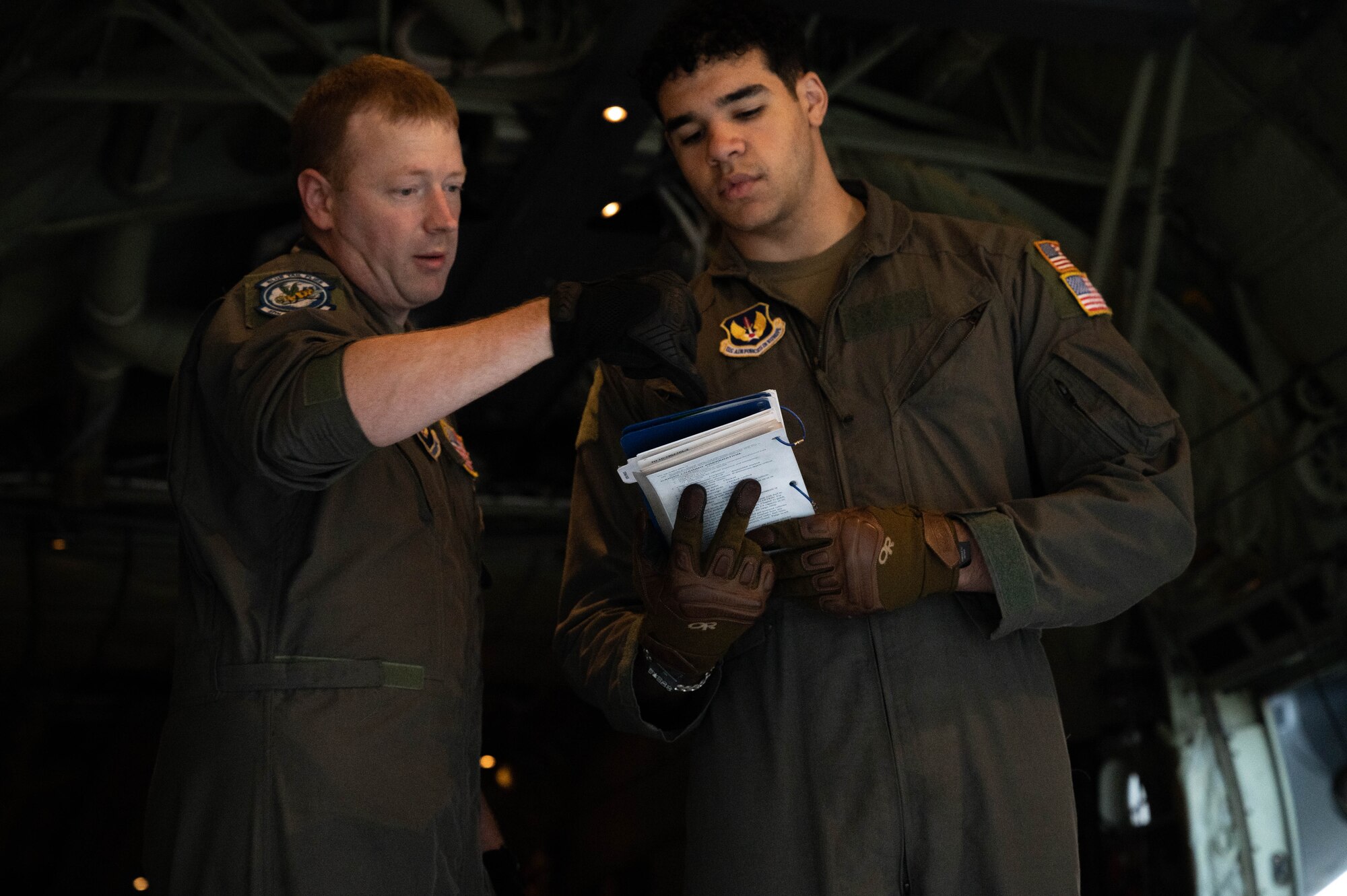 An Airman instructs another Airman on loadmaster procedures.