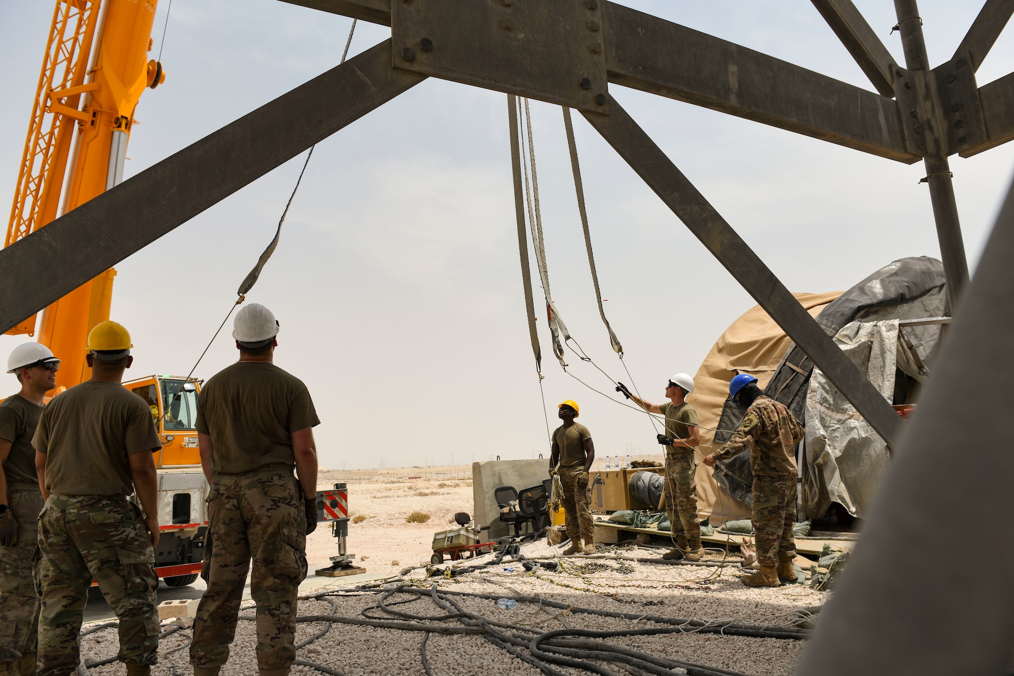 U.S. Air Force Airmen from the 727th Expeditionary Air Control Squadron, Detachment 3, prepare to remove the protective radome covering for an AN/TPS-75 tactical long-range radar system before performing scheduled maintenance July 27, 2021, at Al Udeid Air Base, Qatar. The radar provides a common surveillance and combat identification picture to support battle management command and control for the combined defense of the Arabian Peninsula. (U.S. Air Force by Staff Sgt. Alexandria Lee)