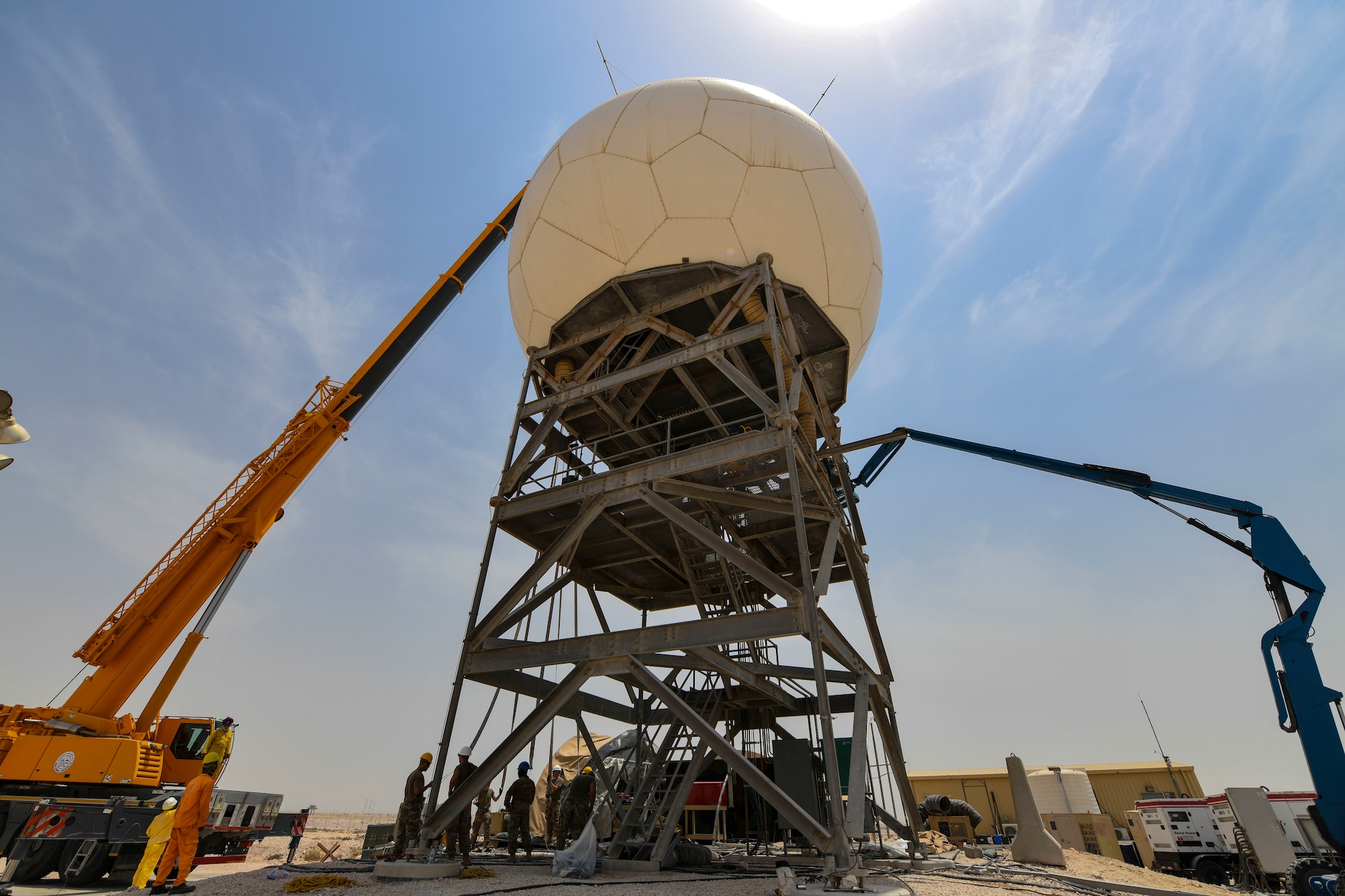 U.S. Air Force Airmen from the 727th Expeditionary Air Control Squadron, Detachment 3, prepare to remove the protective radome covering for an AN/TPS-75 tactical long-range radar system before performing scheduled maintenance July 27, 2021, at Al Udeid Air Base, Qatar. The radar provides a common surveillance and combat identification picture to support battle management command and control for the combined defense of the Arabian Peninsula. (U.S. Air Force by Staff Sgt. Alexandria Lee)