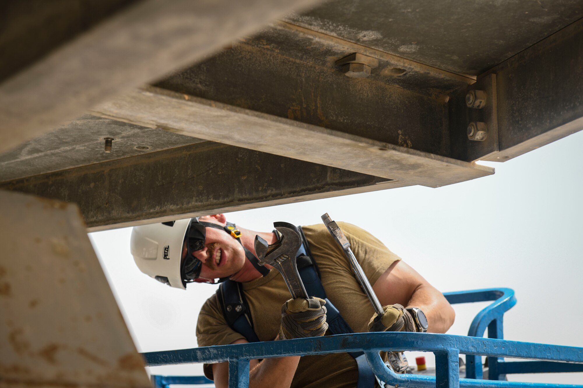 U.S. Air Force Tech. Sgt. Keenan O. Herlocker, NCOIC of Radar Maintenance, 727th Expeditionary Air Control Squadron, Detachment 3, reaches to tighten a bolt on the base of a radome as protection for a newly-replaced AN/TPS-75 radar system from the elements July 27, 2021, at Al Udeid Air Base, Qatar. The radar system provides a common surveillance and combat identification picture to support battle management command and control for the combined defense of the Arabian Peninsula. (U.S. Air Force by Staff Sgt. Alexandria Lee)