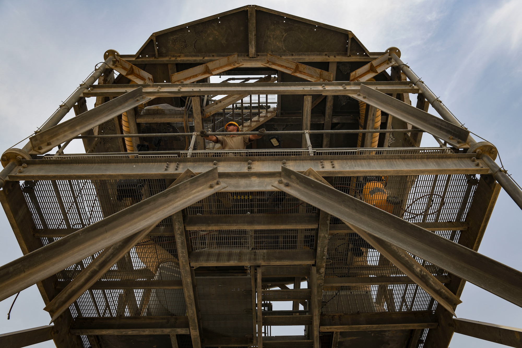 A U.S. Air Force Airman from the 727th Expeditionary Air Control Squadron, Detachment 3, overlooks the removal of a radome and replacement of an AN/TPS-75 radar system as part of regular maintenance July 27, 2021, at Al Udeid Air Base, Qatar. The radar provides a common surveillance and combat identification picture to support battle management command and control for the combined defense of the Arabian Peninsula. (U.S. Air Force by Staff Sgt. Alexandria Lee)
