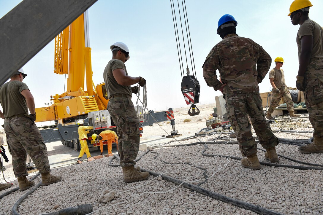U.S. Air Force Airmen from the 727th Expeditionary Air Control Squadron, Detachment 3, prepare to remove the protective radome covering for an AN/TPS-75 tactical long-range radar system before performing scheduled maintenance July 27, 2021, at Al Udeid Air Base, Qatar. The radar provides a common surveillance and combat identification picture to support battle management command and control for the combined defense of the Arabian Peninsula. (U.S. Air Force by Staff Sgt. Alexandria Lee)