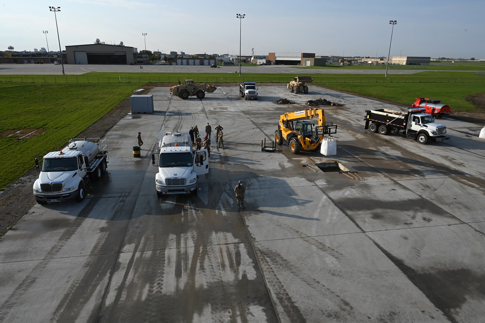 Heavy equipment and military person can be seen from an elevated view as they repair square holes in a concrete training runway at the North Dakota Air National Guard Regional Training Site, Fargo, N.D., Sept. 30, 2021.