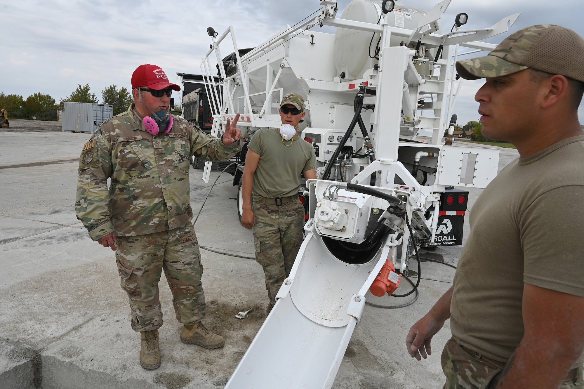 Military personnel place liquid concrete into a square hole using a machine called a volumetric mixer at the North Dakota Air National Guard Base Regional Training Site, Fargo, N.D.