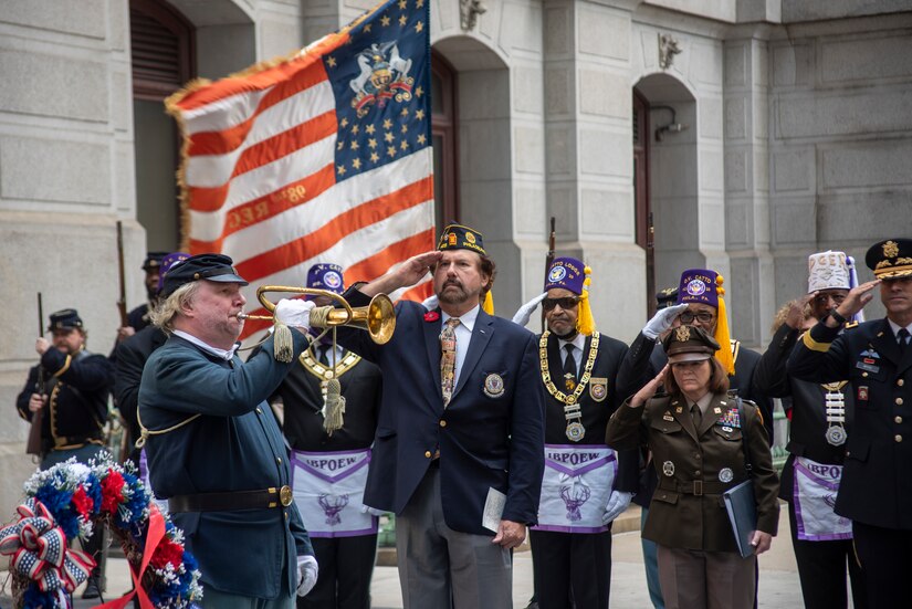 Attendees at the annual Maj. Octavius V. Catto Honor Ceremony salute during the playing of "Taps" at the Catto Monument at Philadelphia City Hall on Oct. 2, 2021.