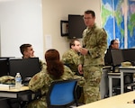 U.S. Air Force Capt. Perry Byrd, 315th Training Squadron instructor, explains concepts to students in the 14N Intelligence Officer course, on Goodfellow Air Force Base, Texas, June 6, 2021. Byrd graduated from the 14N course in 2015 and transferred the course credits towards his master’s degree. (U.S. Air Force photo by Senior Airman Abbey Rieves) *NOTE: This photo has been edited to distort computer classification markers.