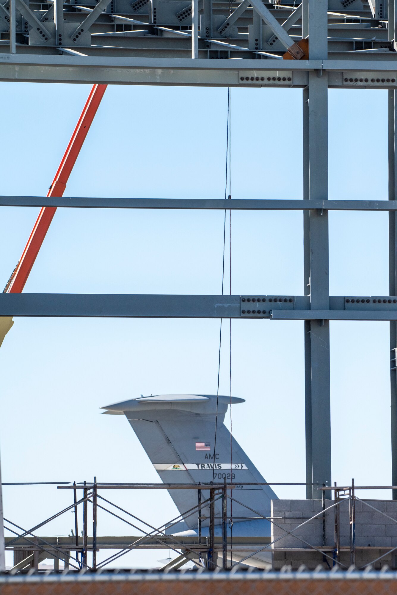 A C-5M Super Galaxy assigned to the 60th Air Mobility Wing/349th AMW is parked behind the construction site of a KC-46A Pegasus 3-bay maintenance hangar Sept. 30, 2021, at Travis Air Force Base, California. After the hangar’s expected completion date of February 2023, the facility will be utilized for the maintenance and upkeep of Travis AFB’s inventory of KC-46 tanker jets. (U.S. Air Force photo by Heide Couch)