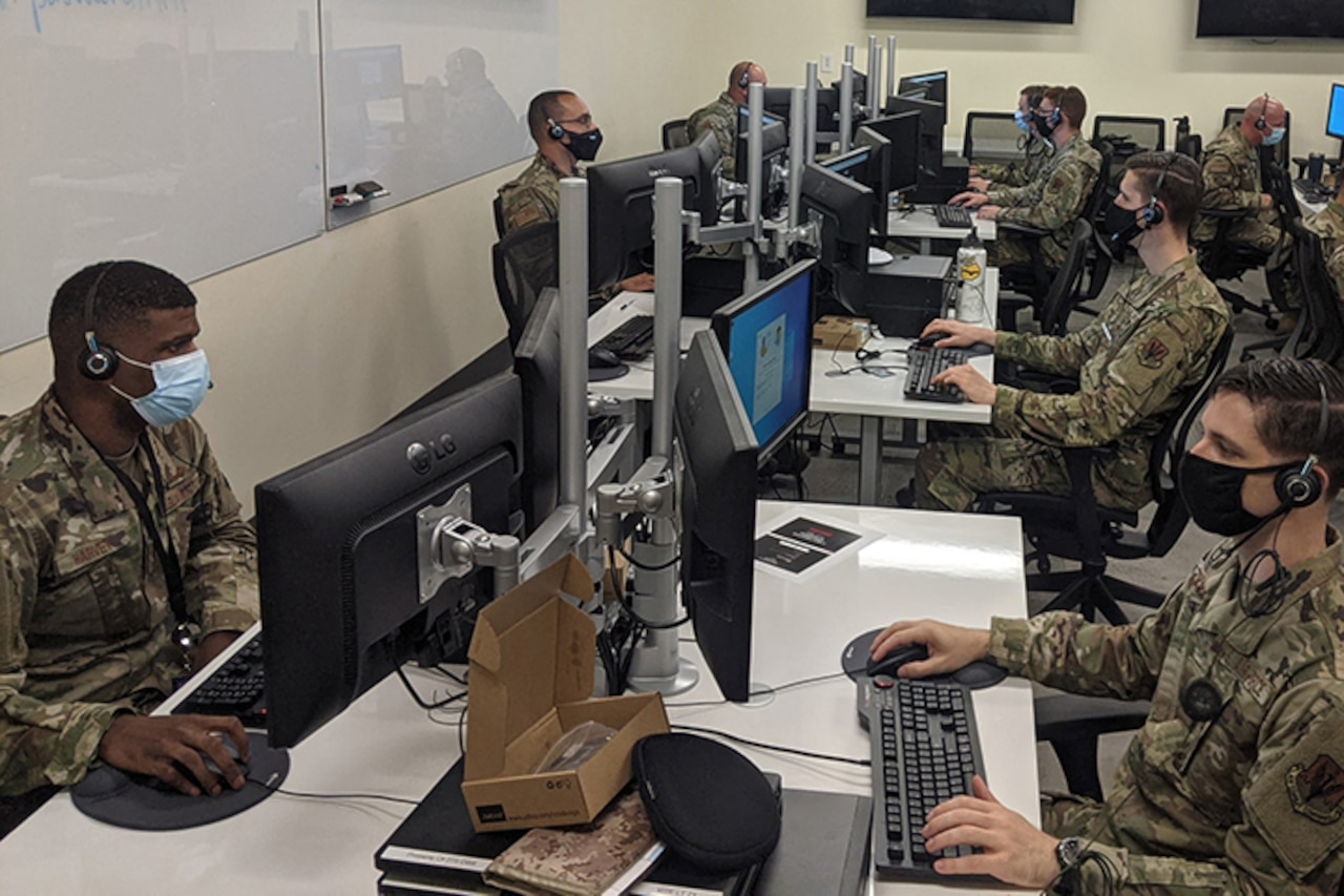 Airmen work on computers.