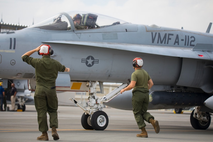 Marines work on a flight line.