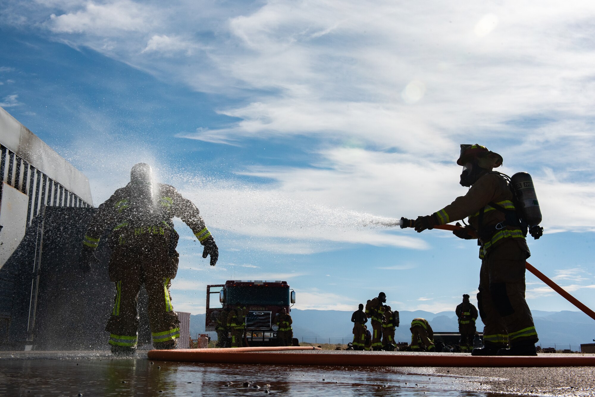 Firefighters from Task Force-Holloman train with members of the 49th Civil Engineer Squadron in a live-fire exercise Sept. 23, 2021 on Holloman Air Force Base, New Mexico. The training ensures TF-H members remain ready and improves interoperability in the event that a fire breaks out in Aman Omid Village. The Department of Defense, through U.S. Northern Command, and in support of the Department of State and Department of Homeland Security, is providing transportation, temporary housing, medical screening, and general support for at least 50,000 Afghan evacuees at suitable facilities, in permanent or temporary structures, as quickly as possible. This initiative provides Afghan evacuees essential support at secure locations outside Afghanistan. (U.S. Air Force photo by Staff Sgt. Kenneth Boyton)
