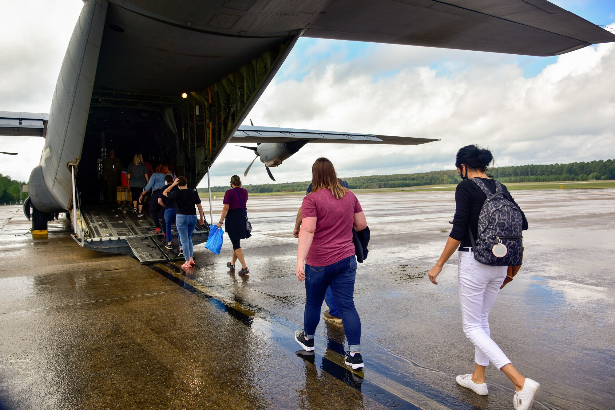 A group of people board a C-130J
