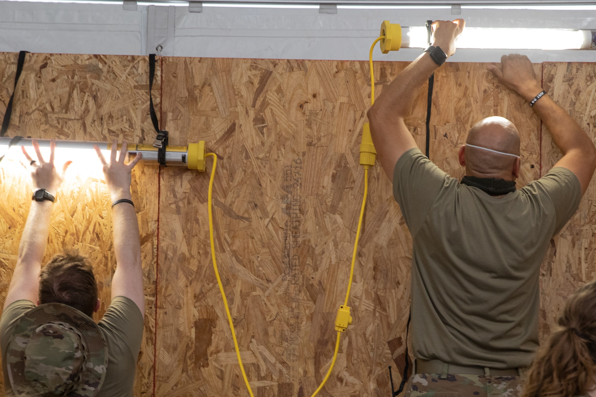 Task Force-Holloman Airmen install lights as they prepare a new triage tent at Aman Omid Village on Holloman Air Force Base, New Mexico, Sept. 22, 2021. The Department of Defense, through the U.S. Northern Command, and in support of the Department of State and Department of Homeland Security, is providing transportation, temporary housing, medical screening, and general support for at least 50,000 Afghan evacuees at suitable facilities, in permanent or temporary structures, as quickly as possible. This initiative provides Afghan evacuees essential support at secure locations outside Afghanistan. (U.S. Army photo by Spc. Nicholas Goodman)